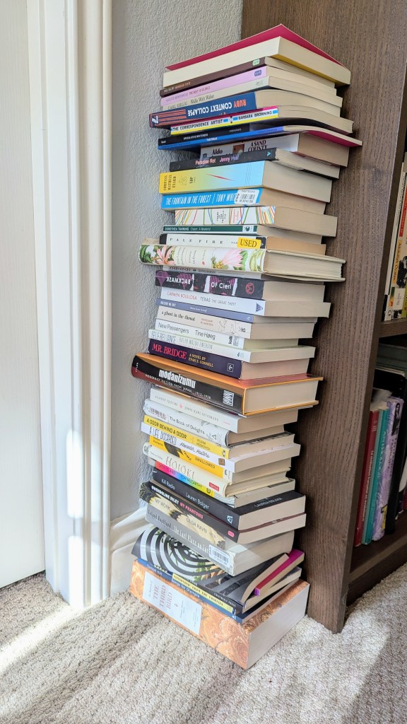 Stack of about 100 books on the floor